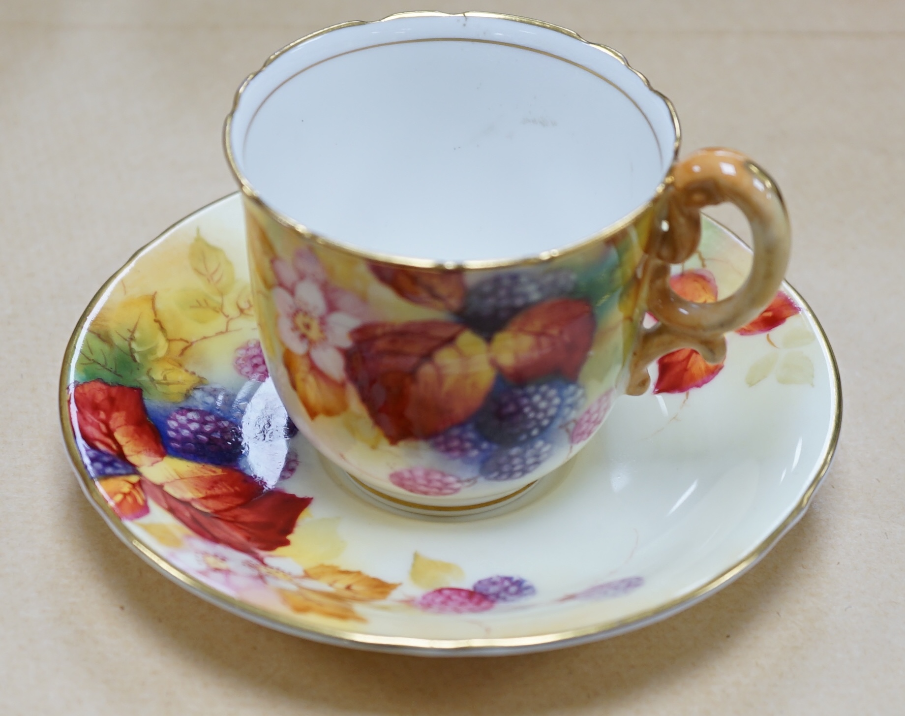 A Royal Worcester fruit painted cup and saucer by Kitty Blake, saucer 11.5cm diameter. Condition - good